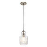 The Riviera-2 1 Light Pendant in Brushed Nickel is a vintage-inspired hanging light featuring a clear ribbed glass shade, ideal for kitchen island lighting. Its exposed bulb offers a warm glow, and the pendant is elegantly suspended by a cord from a circular ceiling mount.