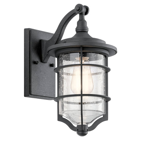 The Royal Marine Outdoor 1 Light Small Wall Lantern in Black features a clear seeded glass shade and a vintage-style bulb. It showcases an elegant design with a curved arm and rectangular wall mount, perfectly complementing a nautical aesthetic.