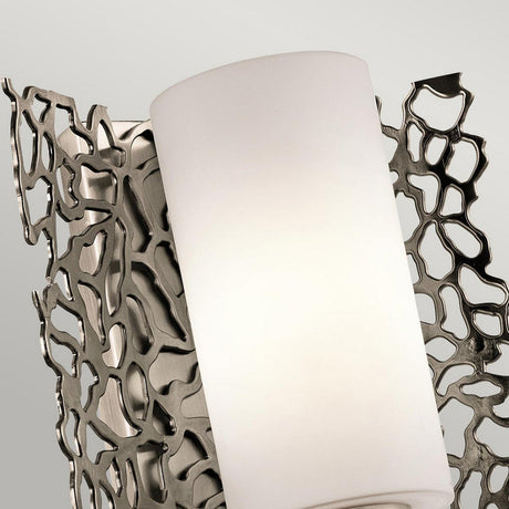 Introducing the Silver Coral 1 Light Wall Light in Silver, featuring a modern metallic design with an abstract, tree-like pattern. Its cylindrical white shade adds a touch of elegance, creating an artistic and contemporary appearance that complements any neutral backdrop.