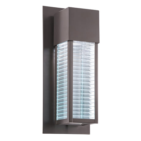 The Sorel Outdoor 1 Light Wall Lantern in Bronze features a modern rectangular design with a textured glass center, emitting a bright white glow.