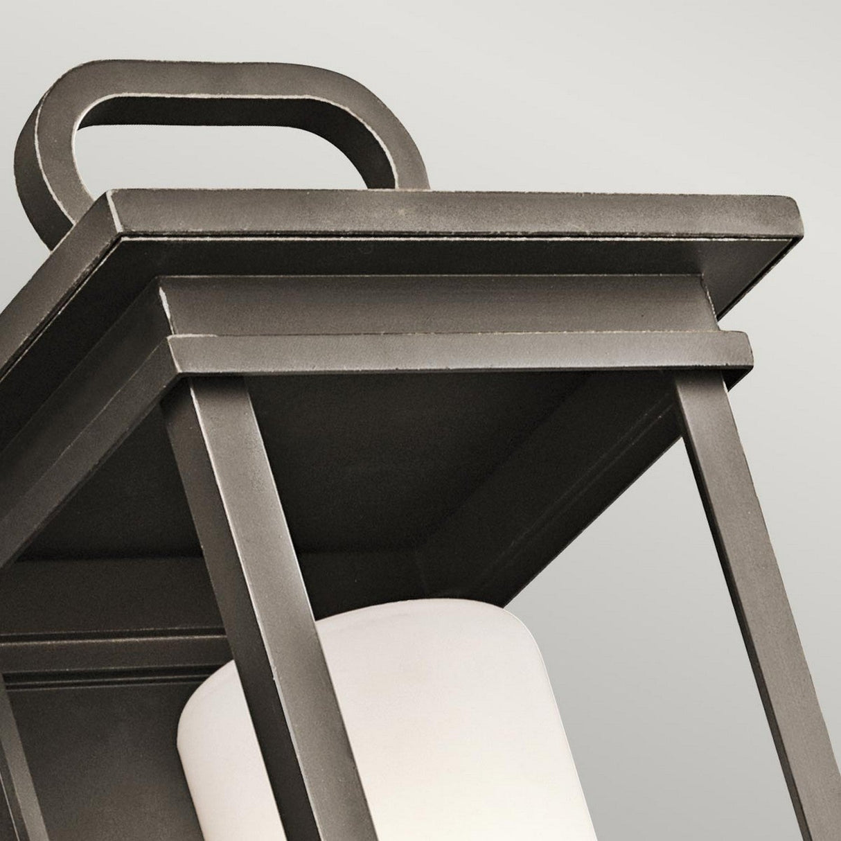 Close-up of the South Hope Outdoor 1 Light Medium Wall Lantern in Rubbed Bronze featuring a rectangular handle, with clean lines and an opal glass interior light fixture. This sleek design is set against a plain white background.
