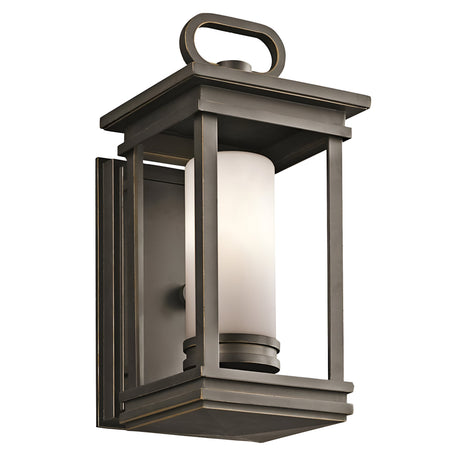 The South Hope Outdoor 1 Light Small Wall Lantern in rubbed bronze features a rectangular metal frame with an opal glass shade at its center.
