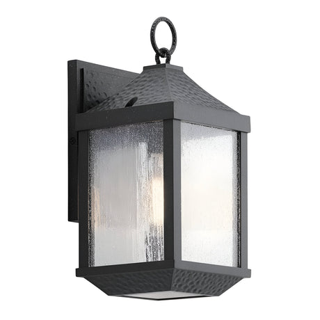The Springfield Outdoor 1 Light Small Wall Lantern - Black is designed with a textured black finish and square design, featuring a clear speckled glass shade. It is IP44 rated for durability and can be mounted on a wall bracket, complete with a decorative ring loop on top.