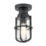 Introducing the Suri Outdoor 1 Light Porch/Pedestal Lantern in Black, featuring a textured industrial-style design with a clear glass shade and metal cage. It showcases an exposed bulb inside, adding nautical charm. This light is mounted on a round base, making it perfect for both indoor and outdoor settings.