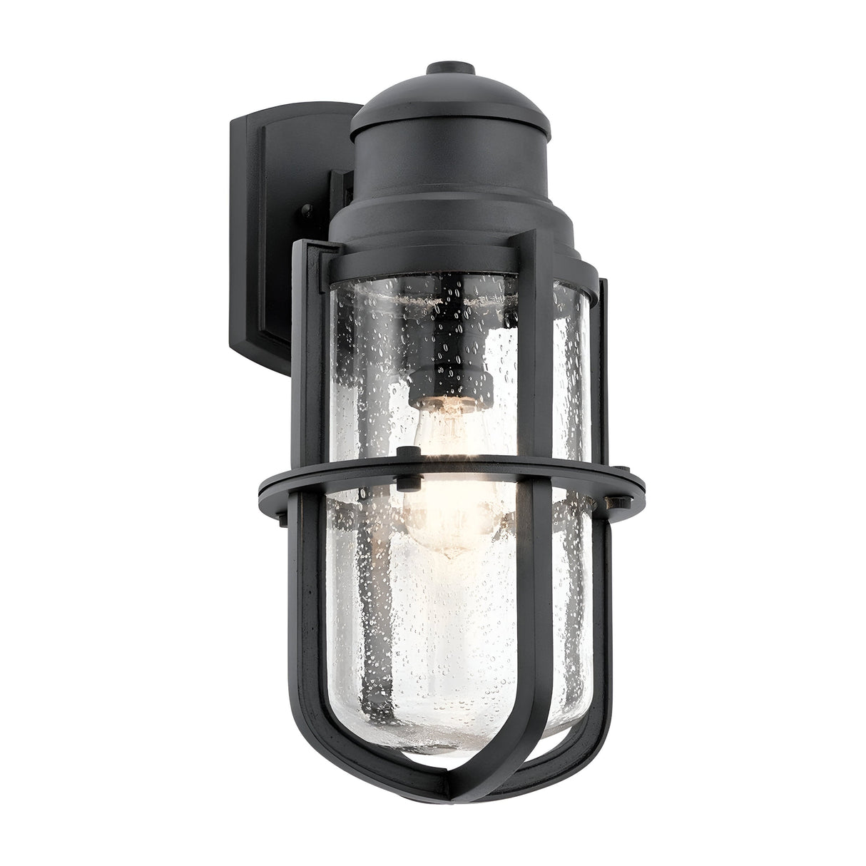 The Suri Outdoor 1 Light Wall Lantern in black features a nautical-inspired design with a clear glass shade and metal details. Protective bars encase the cylindrical glass, revealing the visible bulb inside. This fixture is mounted on a rectangular wall plate, making it perfect for outdoor lighting.