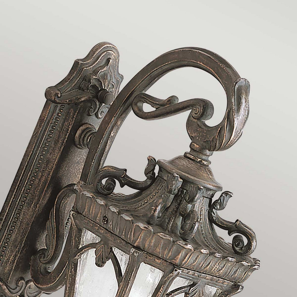 The Tournai Outdoor 1 Light Medium Wall Lantern - Bronze is an elegant, vintage-inspired lantern with a sophisticated aged bronze finish and decorative accents. It showcases intricate scrollwork, leaf designs, and seedy glass panels, making it a delightful addition to any outdoor setting with its antique charm.