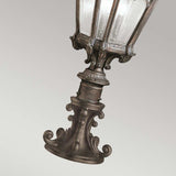 The Tournai 2 Light Large Pedestal in bronze boasts vintage-style design with intricate details and clear seedy glass panels. Diagonally positioned against a neutral backdrop, this outdoor fixture adds a touch of elegance to any space.