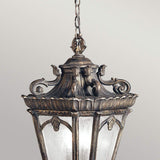 Introducing the Tournai Outdoor 3 Light Extra Large Chain Pendant in Bronze, an ornate hanging European lantern with a vintage design. It boasts intricate scrollwork, a dark bronze finish, frosted glass panels, and is suspended by a decorative bronze chain.