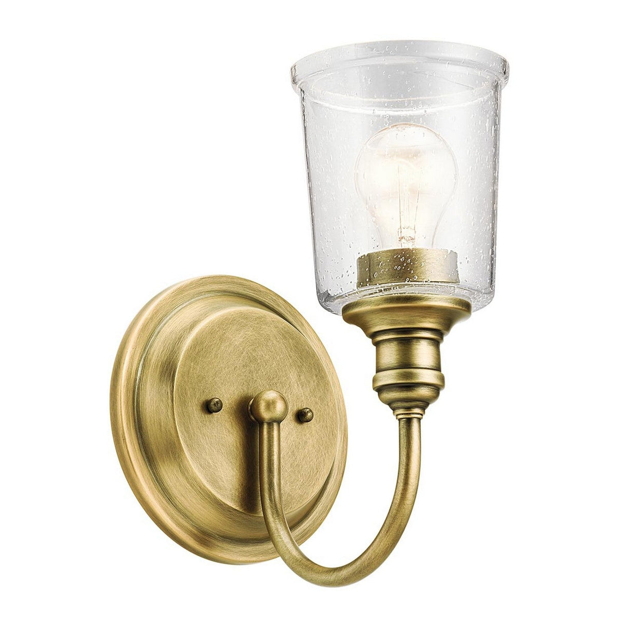 The Waverly 1 Light Wall Light in Natural Brass boasts a round base and curved arm that supports a clear seeded glass shade, radiating vintage charm with its visible light bulb. This natural brass wall fixture effortlessly combines classic and modern design elements.