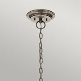 The Waverly 5 Light Chandelier - Silver elegantly hangs with its metal ceiling fixture, showcasing a round base and attached chain. The chain weaves through a circular mount, highlighted by seeded glass shades and a lustrous silver finish, all against a simple light gray backdrop.