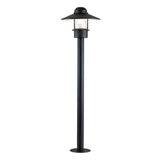 Introducing the Klampenborg 1 Light Bollard - Black, a tall outdoor lamp post with a modern design. It features a clear glass enclosure housing a light bulb and boasts a sleek pole reminiscent of the Klampenborg style. Its pointed roof and round base add an elegant touch to any outdoor lighting arrangement.