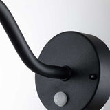 A close-up of the black Klampenborg 1 Light Outdoor Wall Light showcases its circular wall-mounted arm with a PIR sensor at the base. This elegant fixture, embodying Scandinavian design, gracefully curves outward from its round base against a plain white background.