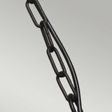 A close-up of the Klampenborg 1 Light Outdoor Chain Pendant - Black features an IP44-rated black metal chain intertwined with a black cable, set against a plain, light gray background. The Scandinavian design elements add sophistication as the chain and cable run diagonally across the image.