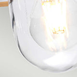A close-up of the Klampenborg 1 Light Outdoor Chain Pendant reveals an illuminated vintage-style bulb. Its clear glass casing and glowing filament create a warm contrast against the light gray background, showcasing Scandinavian minimalism with a hint of stainless steel elegance.