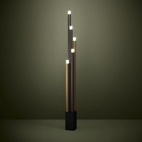 Korbelle LED floor lamp with five staggered square uprights in black, brown and gold, each topped with a frosted cap light, set on a black square base against an olive-green background.