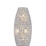 The Kos 4 Light Crystal Floor Lamp features a tall, oval-shaped design accented with sparkling crystals and a polished chrome finish, reflecting light beautifully in all directions against a white background.