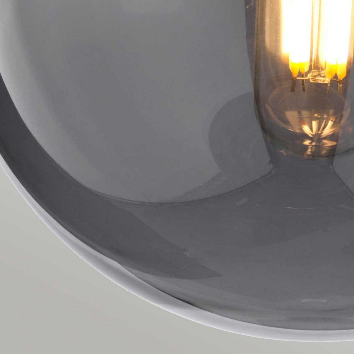 Close-up of a glowing filament bulb inside the glossy, mirror glass shade of the Kula 1 Light Wall Light - Polished Nickel, highlighting its warm light and texture. This modern retro wall light with its polished nickel finish adds a touch of elegance to any space.