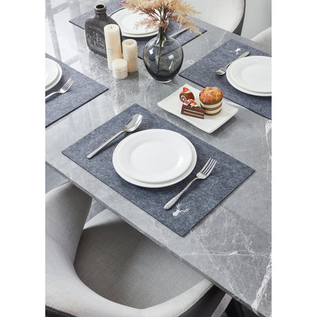 Lakandava Placemat in dark grey heathered felt with embroidered stag motif, set on a marble dining table with white plates, cutlery, and dessert plate.