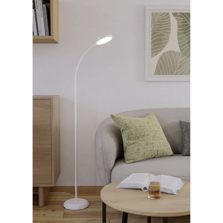 Lauro LED Floor Lamp in white, shown in a living room with a round base, tall stem and flexible gooseneck arm topped by a round LED head, beside a grey sofa.