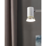 GU10 LED bulb with faceted glass body and satin front, shown lit in a chrome wall light fitting, giving cool white 4000K light.