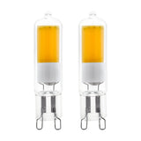 Two LED capsule bulbs with G9 pin base, clear glass casing showing an amber-toned LED panel above a white collar, shown on a plain white background.