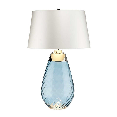 The Lena 2 Light Large Blue Table Lamp features a mouth-blown glass base in blue with a distinctive textured spiral pattern, beautifully paired with an off-white lampshade. A gleaming metallic accent near the bulb holder enhances its sophisticated design.