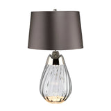 Introducing the Lena 2 Light Small Smoke Table Lamp, featuring a slate shade and a smoke-tinted glass base with elegant swirling patterns. Metallic accents elevate its sophisticated appearance, while the innovative Dual-Lit system provides versatile lighting options.