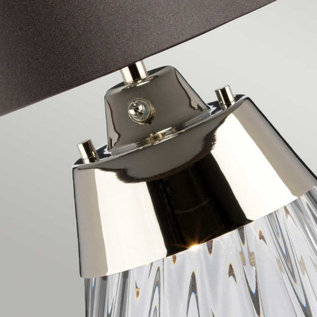 Close-up of the Lena 2 Light Small Smoke Table Lamp - Slate Shade, showcasing its transparent smoke-tinted glass base with shiny metallic accents. The dark slate shade provides a sleek contrast, ideal for contemporary interior decor. Its innovative Dual-Lit system enhances the ambiance.