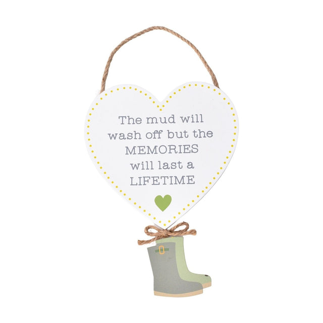 White heart-shaped hanging plaque with jute cord, yellow dotted border, grey text reading The mud will wash off but the MEMORIES will last a LIFETIME, a small green heart, and green wellington boots.