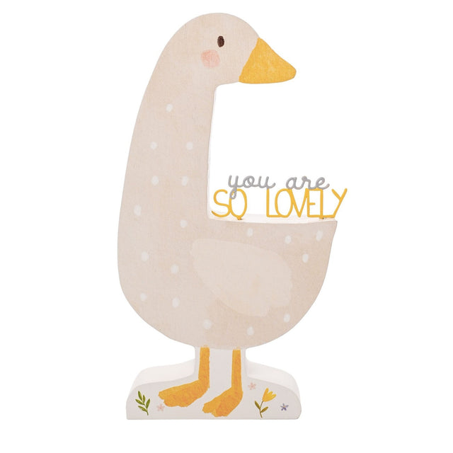 Wooden goose-shaped plaque in beige with white spots, mustard yellow beak and feet, curved neck framing "you are SO LOVELY" text, on a plain white background.