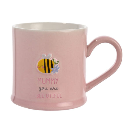 Pink stoneware mug with an embossed smiling bee, lilac flower and leaves, reading "MUMMY you are BEE-UTIFUL", on a plain white background.
