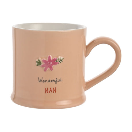 Peach stoneware mug with white interior and curved handle, featuring an embossed pink flower with green leaves and "Wonderful NAN" text, shown on a plain white background.