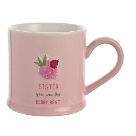 Pink stoneware mug with embossed strawberry and ladybird design, white interior, rounded handle, and "SISTER you are the BERRY BEST" text, shown on a plain background.