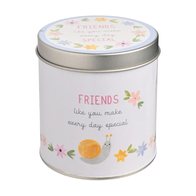 Round white tin scented candle with lid, printed with "FRIENDS like you make every day special" in pink and grey, featuring an orange snail and pastel floral border, on a plain white background.