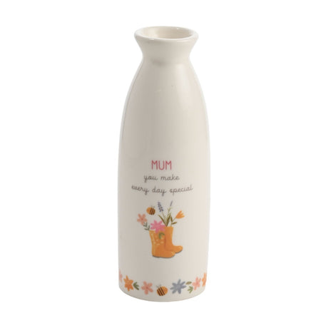 White ceramic stem vase with "MUM you make every day special" text, yellow wellington boots filled with flowers, and a floral bee border, on a plain white background.
