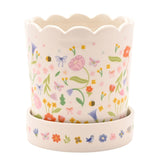 Off-white ceramic planter with scalloped rim, floral and butterfly print, matching saucer featuring birds and flowers, shown on a plain background.
