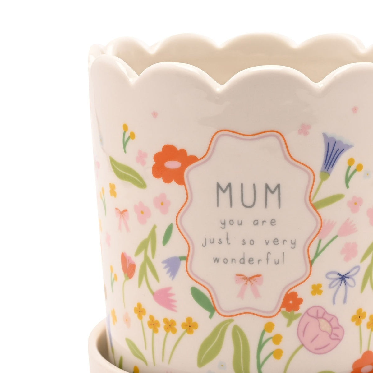 Off-white stoneware planter with scalloped rim and wildflower print in pink, orange, yellow and lilac, featuring a framed "MUM you are just so very wonderful" panel with a small pink bow.
