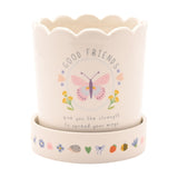 Off-white round stoneware planter with scalloped rim, Good Friends text, butterfly, flower and heart decals, matching saucer with small animal and floral motifs, white background.