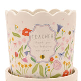 White stoneware planter with scalloped rim and saucer, featuring a floral meadow print with bees and a frame reading "TEACHER thank you for helping me grow".