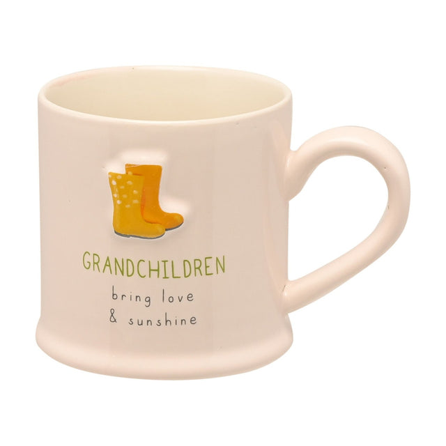 Cream stoneware mug with embossed yellow and orange welly boots and "GRANDCHILDREN bring love & sunshine" text, shown on a plain white background.