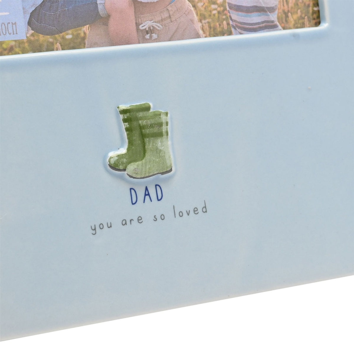 Blue glazed stoneware photo frame for a 6 x 4in landscape photo, with raised green welly boots and "DAD you are so loved" text on the border.