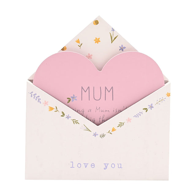 Wooden envelope plaque for Mum in white with a floral border, featuring a pink heart insert reading "MUM" and "love you" lettering on the envelope front, shown on a plain background.