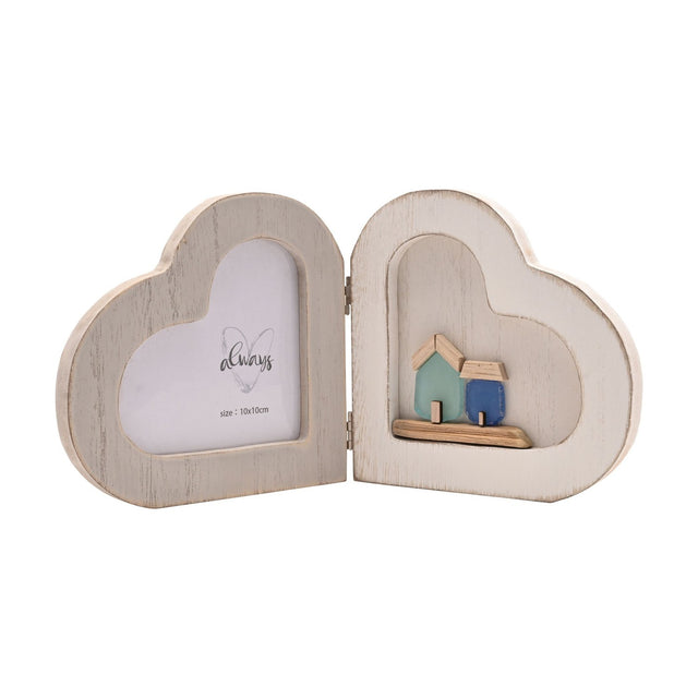 White wooden folding double heart photo frame with a heart-shaped photo window on one side and a small seaside scene of two wooden houses on the other.