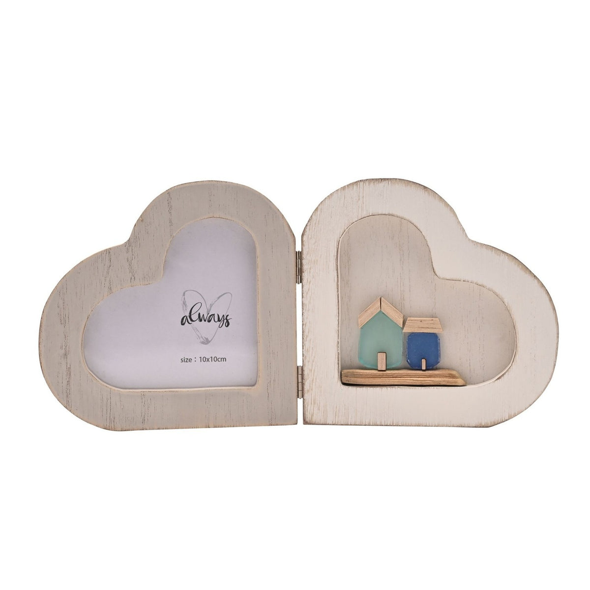 Folding wooden double heart photo frame in white, one side with a heart-shaped photo window, the other framing a small seaside scene with green and blue houses on a wooden base.