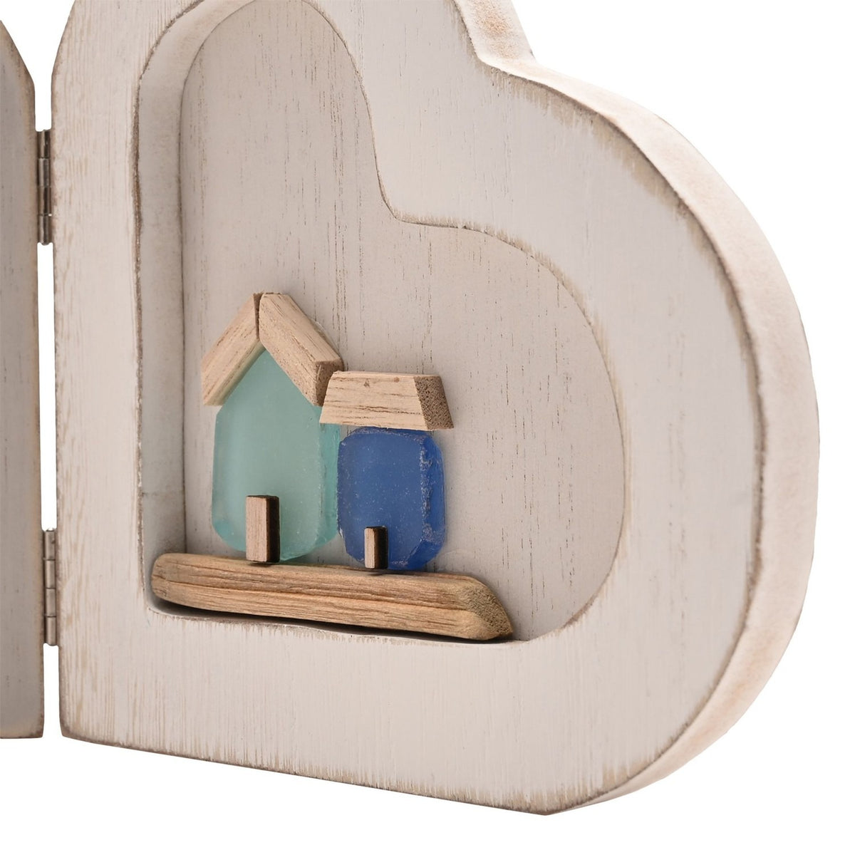 Close-up of the By the Sea Folding Double Heart Wooden Photo Frame in white, showing the right heart's alcove with two sea-glass style houses in green and blue on a natural wood base.