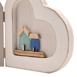 Close-up of the By the Sea Folding Double Heart Wooden Photo Frame in white, showing the right heart's alcove with two sea-glass style houses in green and blue on a natural wood base.