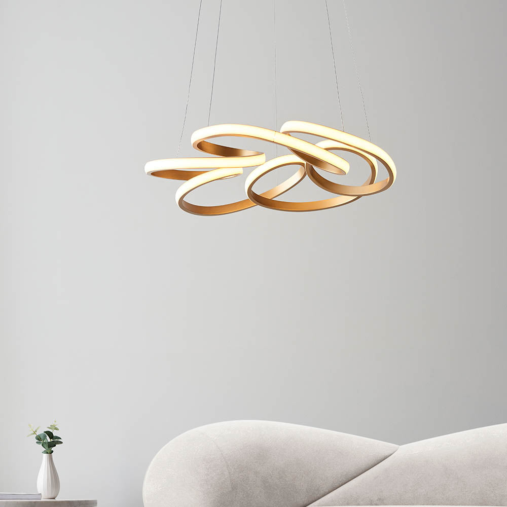 Tolmere Multi Spiral LED Pendant in satin gold by Lighting No.1, illuminated above a cream sofa in a neutral living room.