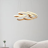 Tolmere Multi Spiral LED Pendant in satin gold by Lighting No.1, illuminated above a cream sofa in a neutral living room.