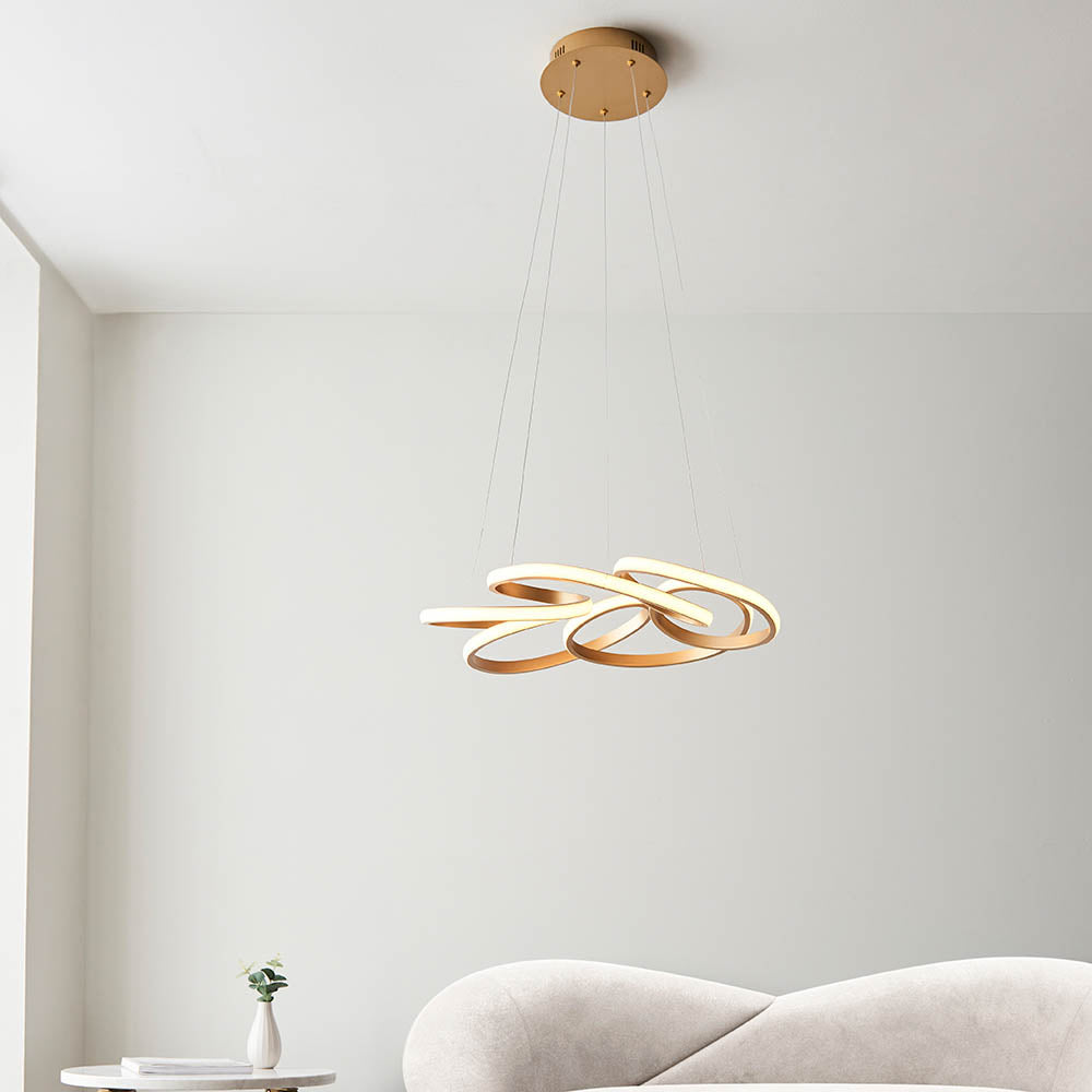 Tolmere Multi Spiral LED Pendant in satin gold by Lighting No.1, suspended from a round ceiling plate above a cream sofa in a living room.
