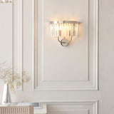 Calverdale Cut 2 Light Wall Light in bright nickel with faceted cut glass shades, illuminated on a panelled off-white wall above a console.